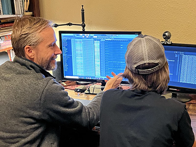 Photo of Justin working with a person at a computer